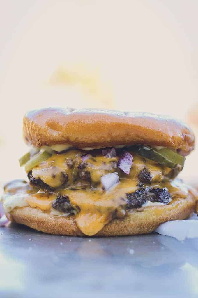 large vertical image of juicy, melty and greasy, perfect cheeseburger