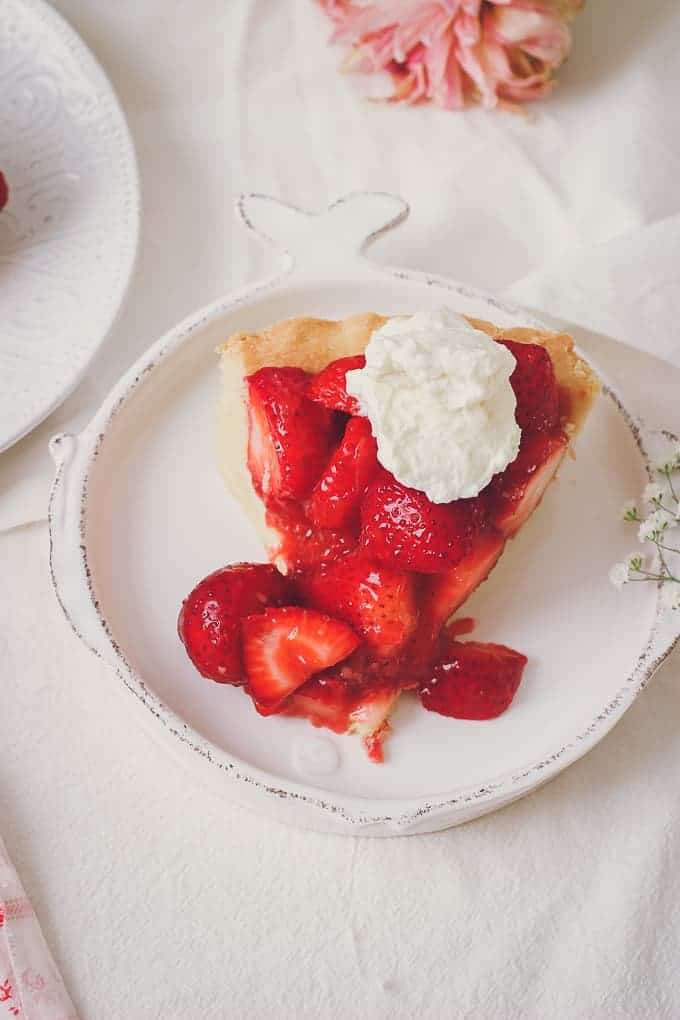 close up view of one piece of strawberry pie with whipped cream