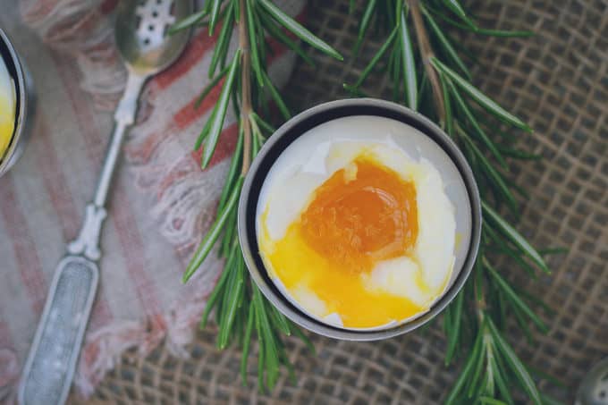 This is a photo of a perfect soft-boiled egg, shot from above. The yolk is soft-runny and golden, with a perfectly set egg white.
